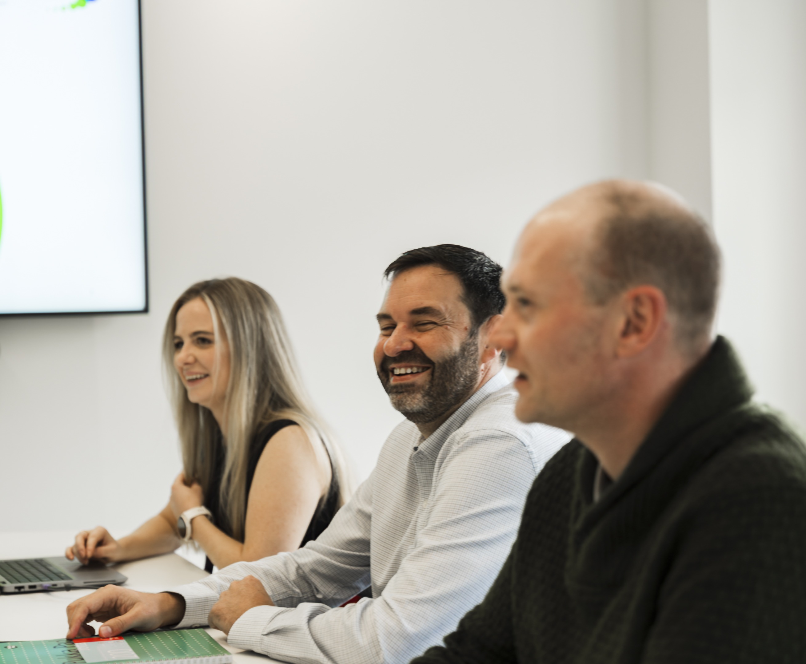 One woman and two men sitting side by side in a meeting scenario