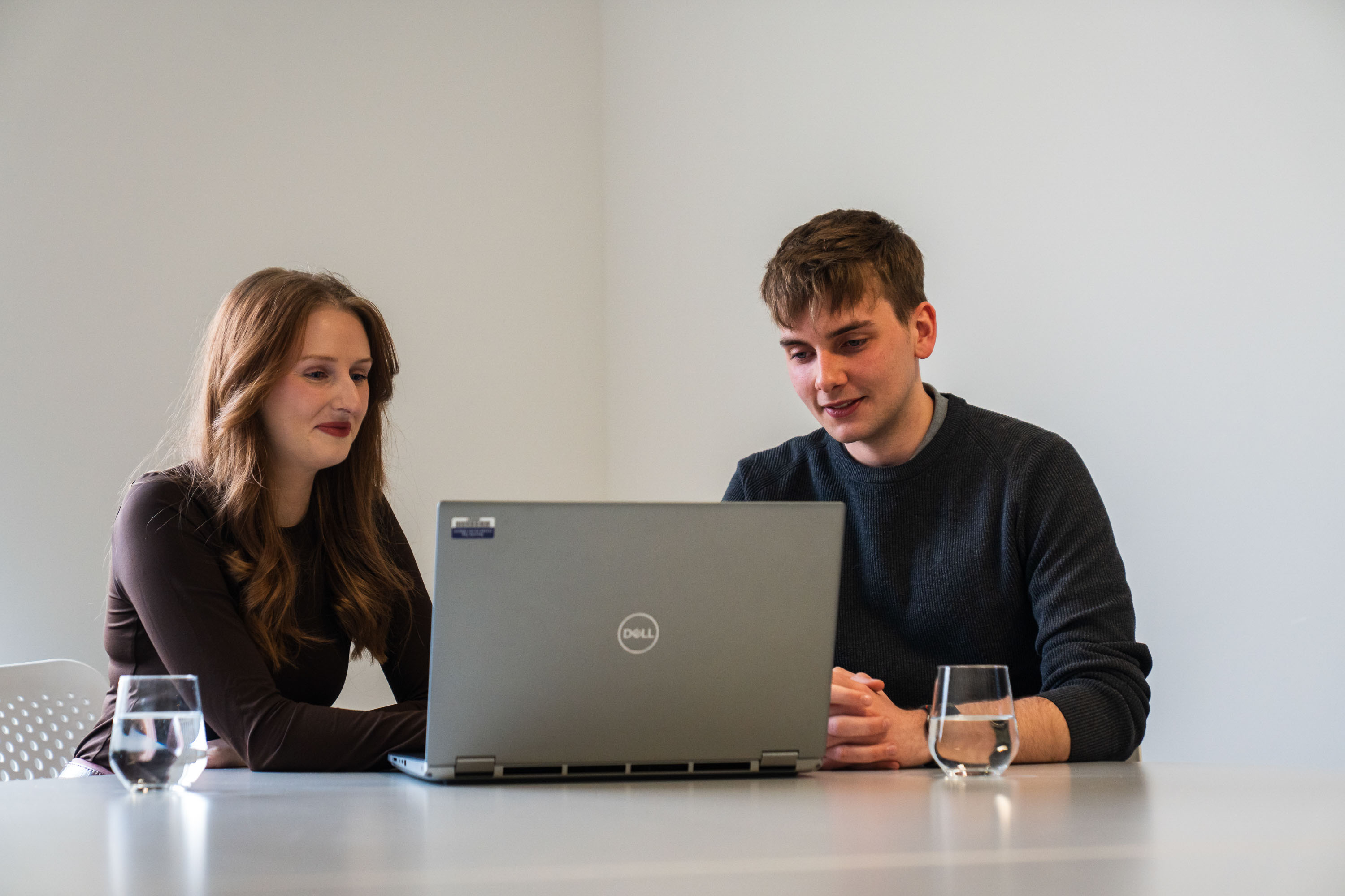 Woman and young man looking at laptop together
