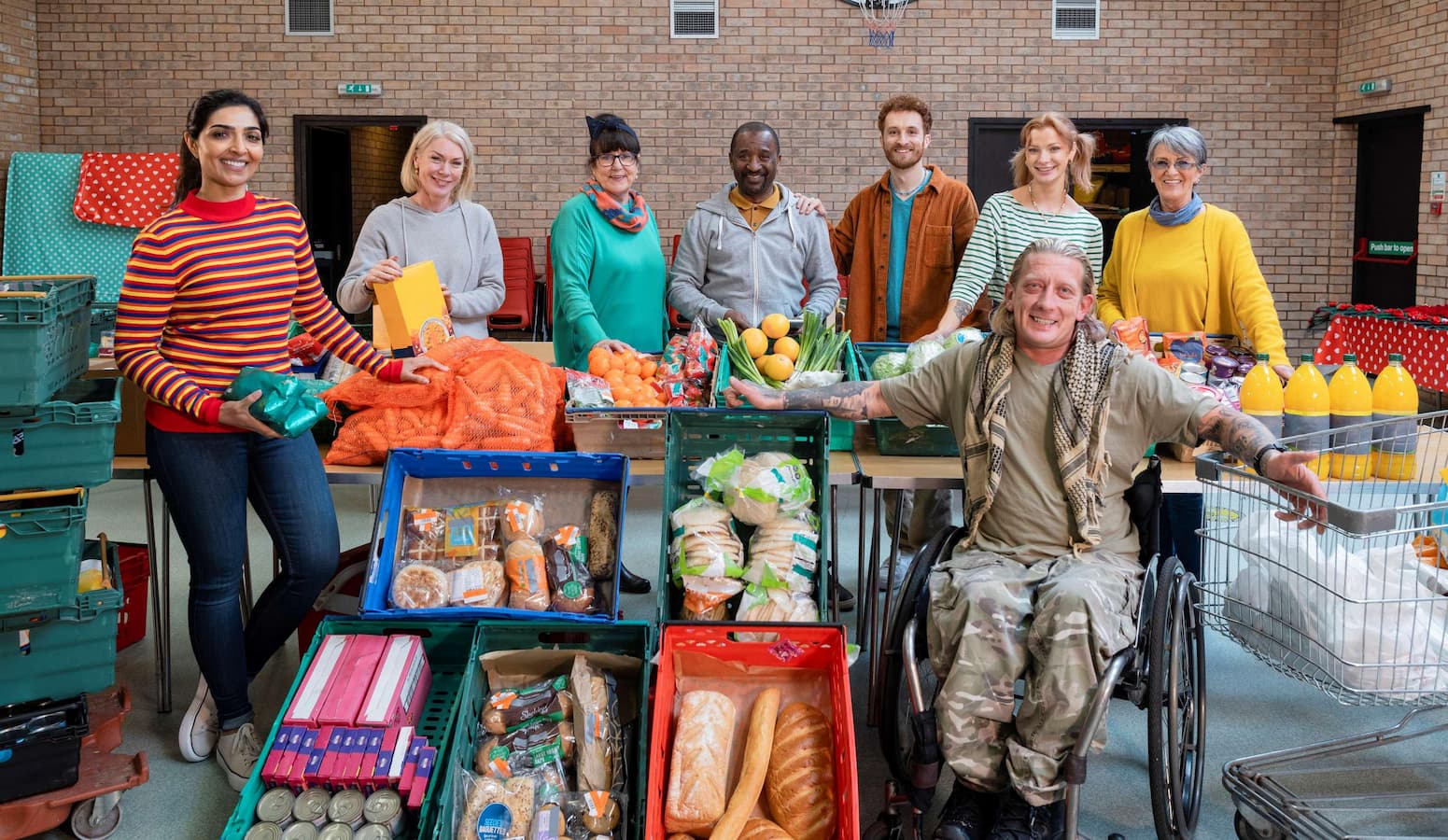 Group of charity workers at a food bank with crates of food