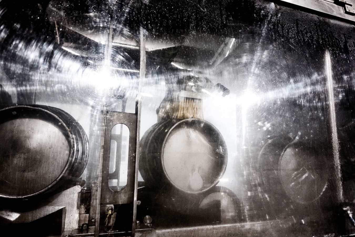 Barrels being machine cleaned in an industrial setting