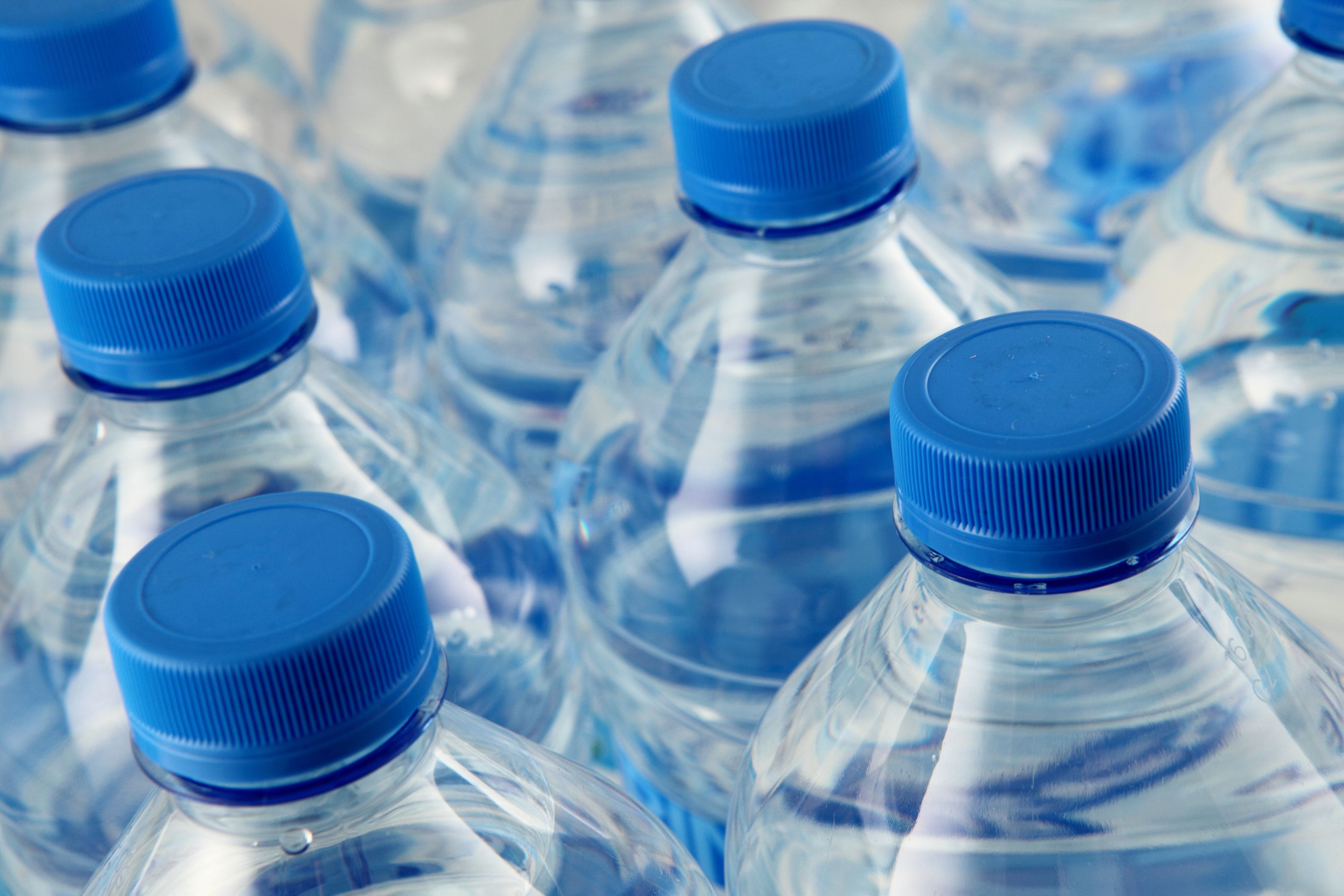 Close-up of bottled water with blue bottle tops