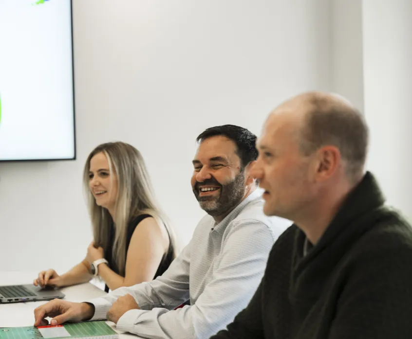 One woman and two men sitting side by side in a meeting scenario