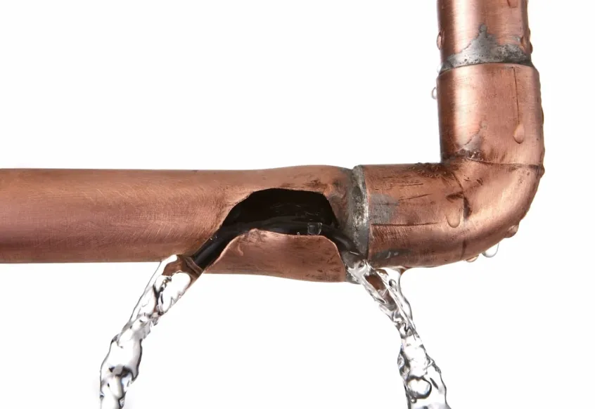 Water leaking from a burst copper pipe