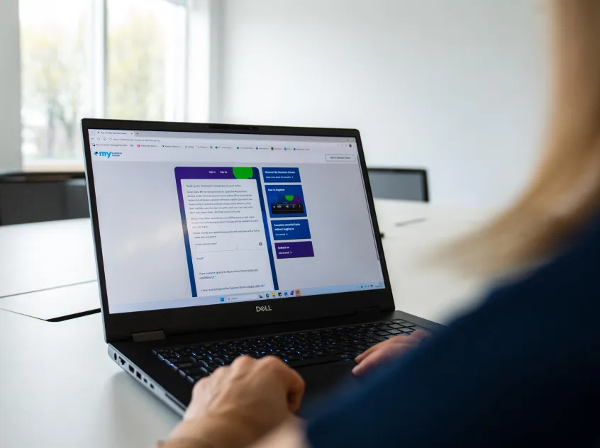 Over the shoulder or woman viewing My Business Stream sign-in page on a laptop
