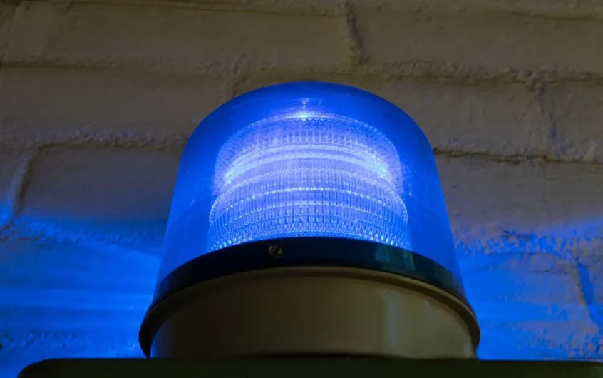 Flashing blue light mounted on a brick wall