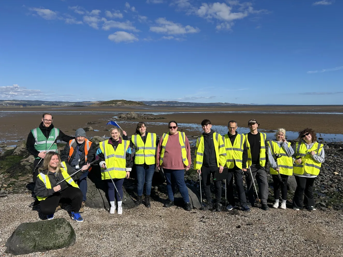 People in high-vis vests doing a beach clean