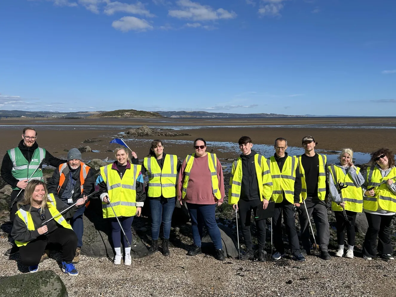 People in high-vis vests doing a beach clean