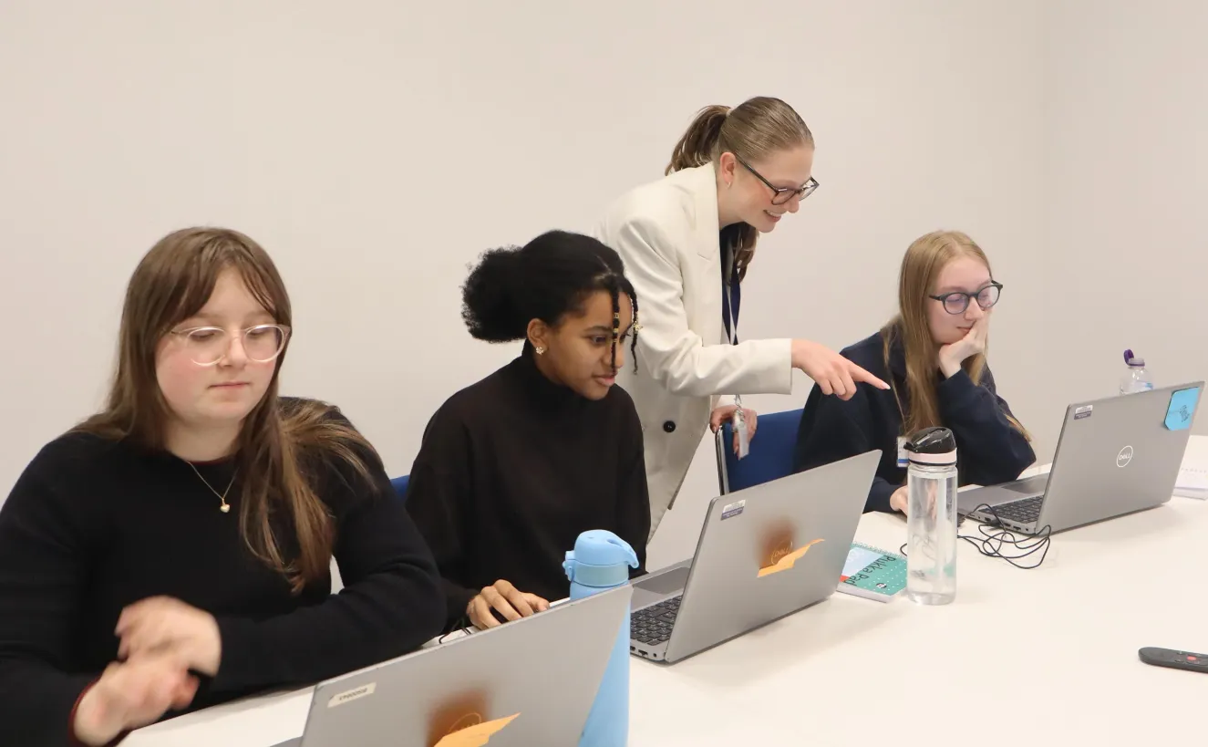 Career ready students in meeting room looking at laptops