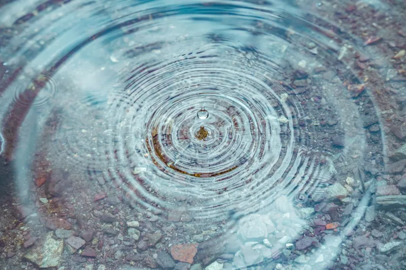 Close up of water drop rising from shallow pool