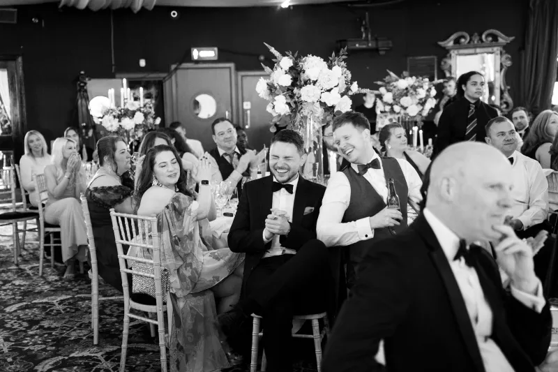 Black & white shot of colleagues laughing and smiling at dinner tables at Business Stream Awards Night