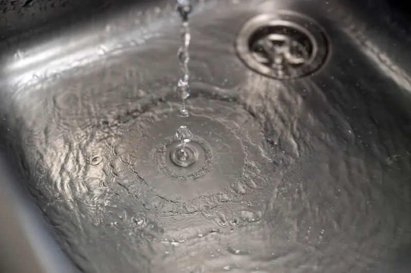Water drops landing in a metallic sink