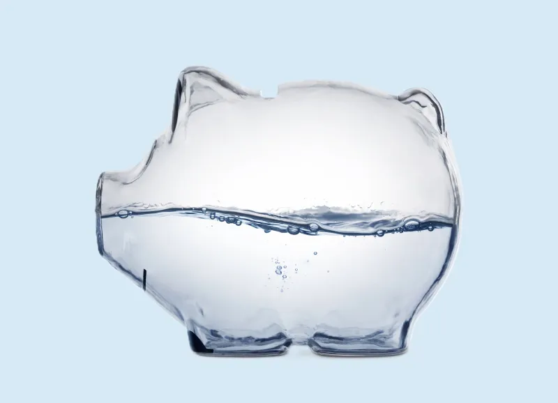 Glass piggy bank half full of water