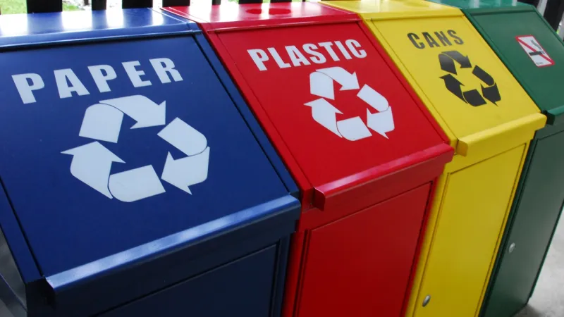 Colour-coded recycling bins for paper, plastic and cans.