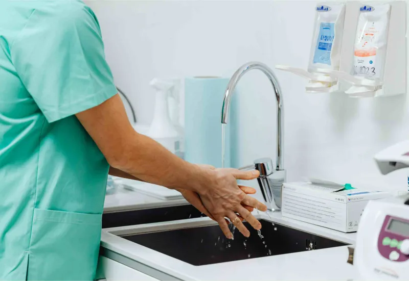 Medical person washing hands in sink