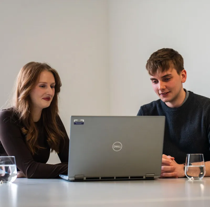 Woman and young man looking at laptop together