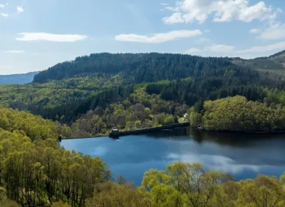 Glen Finglas reservoir in foreground with hills and forest in background.